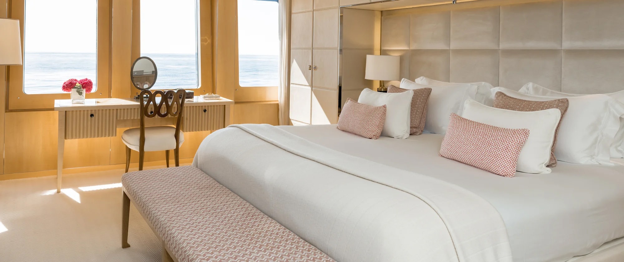 a bed with white sheets and pillows aboard LOON Yacht for Charter