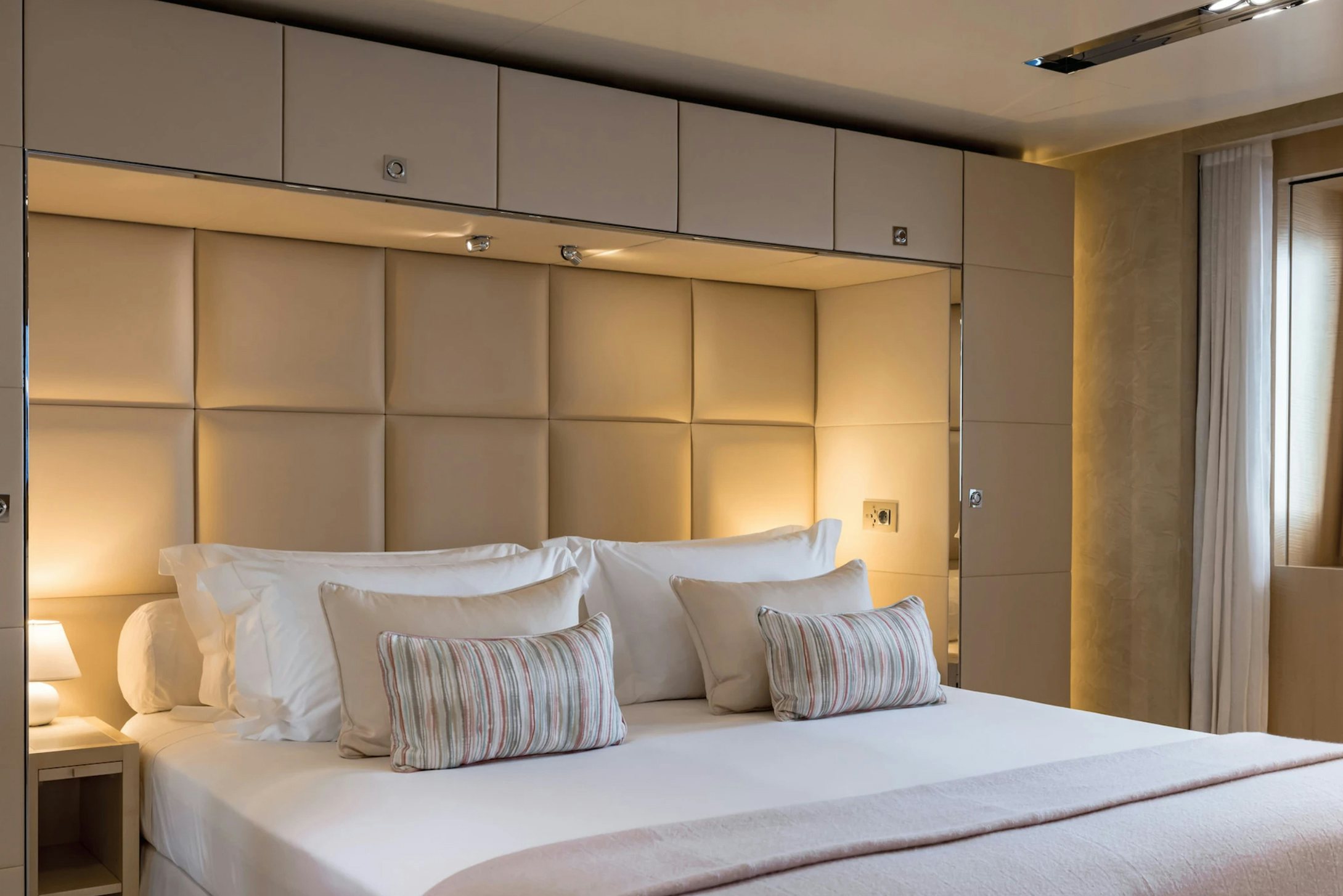 a bed with white sheets aboard LOON Yacht for Charter