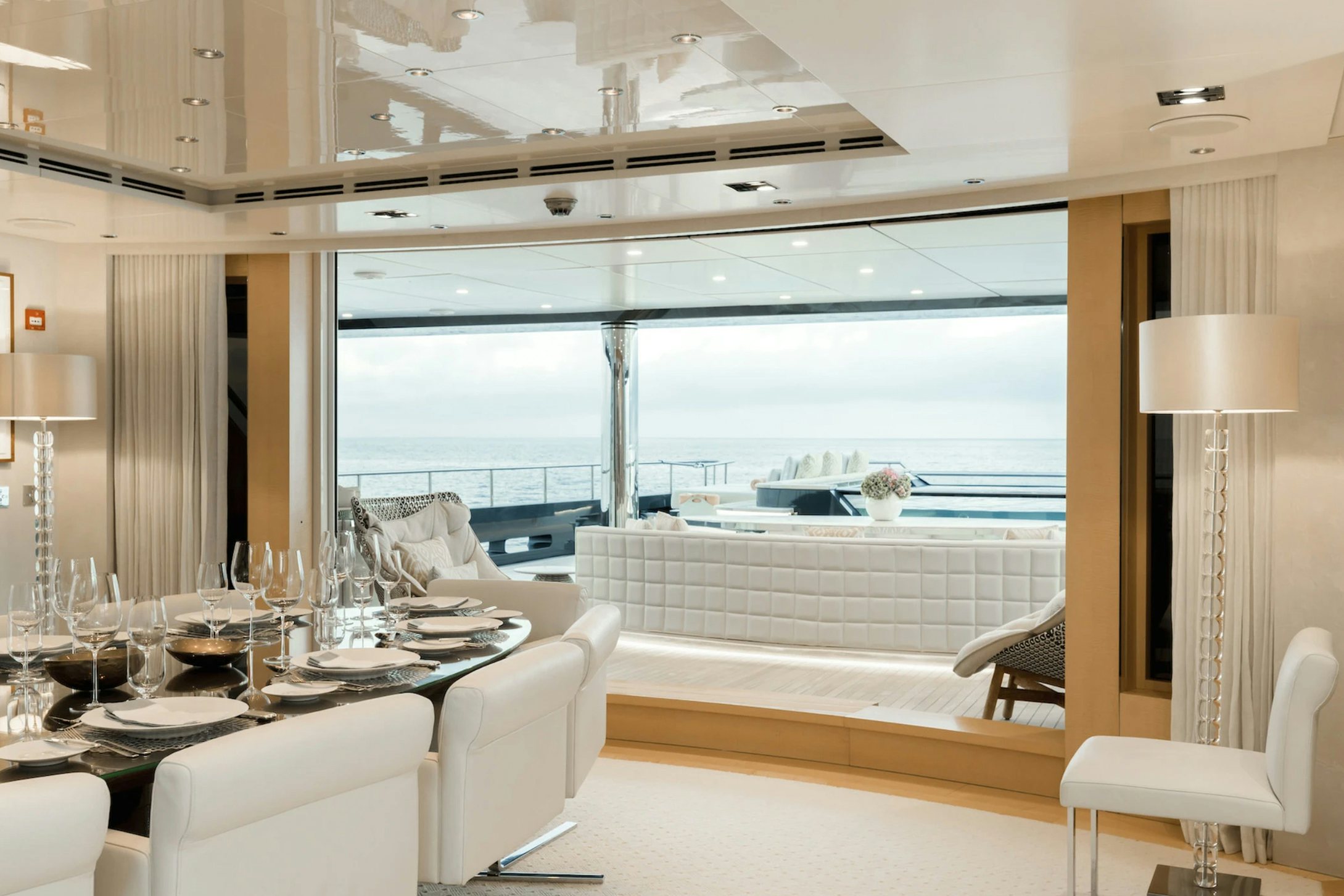 a room with a table chairs and a large window aboard LOON Yacht for Charter