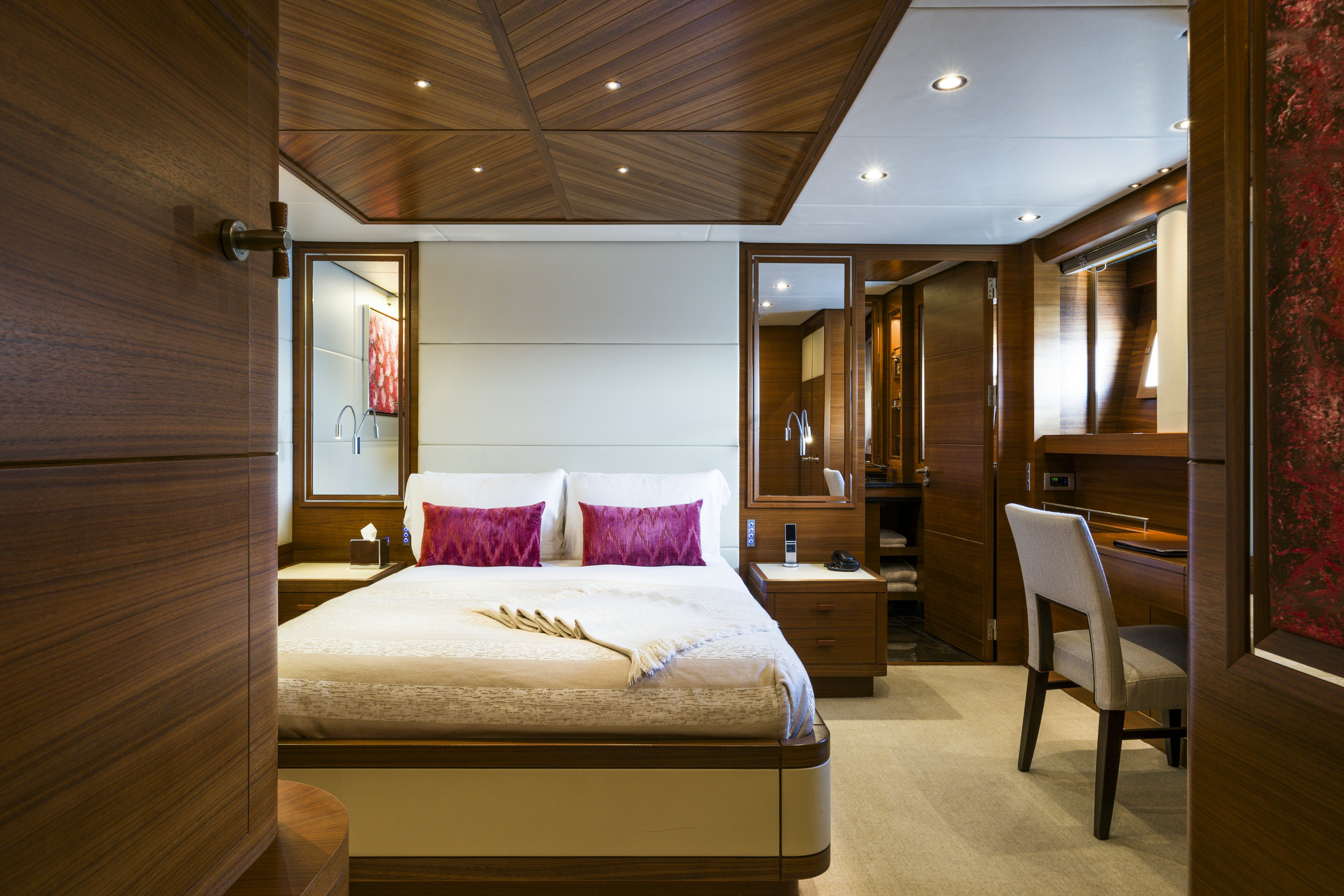 a bedroom with a bed and a chair aboard BALISTA Yacht for Sale