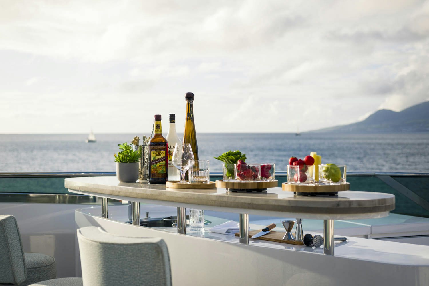 a table with food and drinks on it by the water aboard BALISTA Yacht for Charter