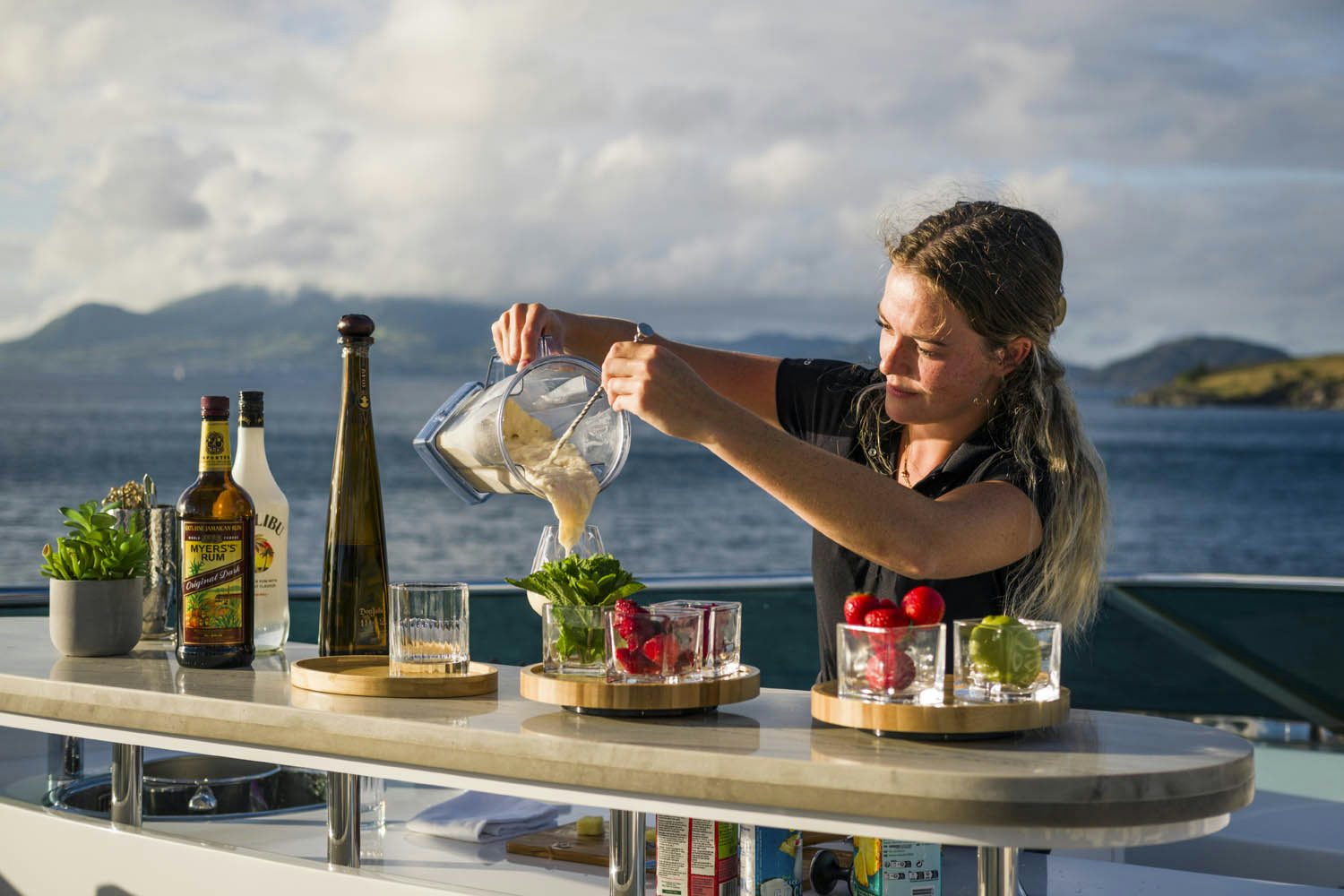 a man pouring a glass of wine aboard BALISTA Yacht for Charter