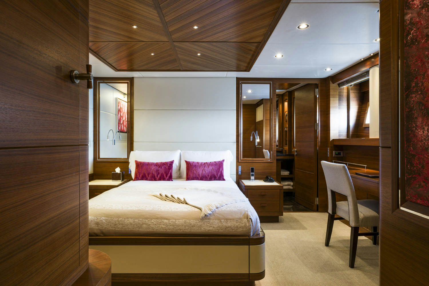 a bedroom with a bed and a chair aboard BALISTA Yacht for Charter