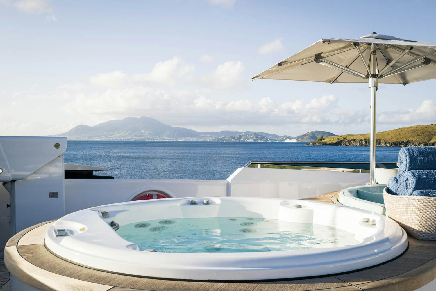 a pool with a umbrella and a view of the water aboard BALISTA Yacht for Charter