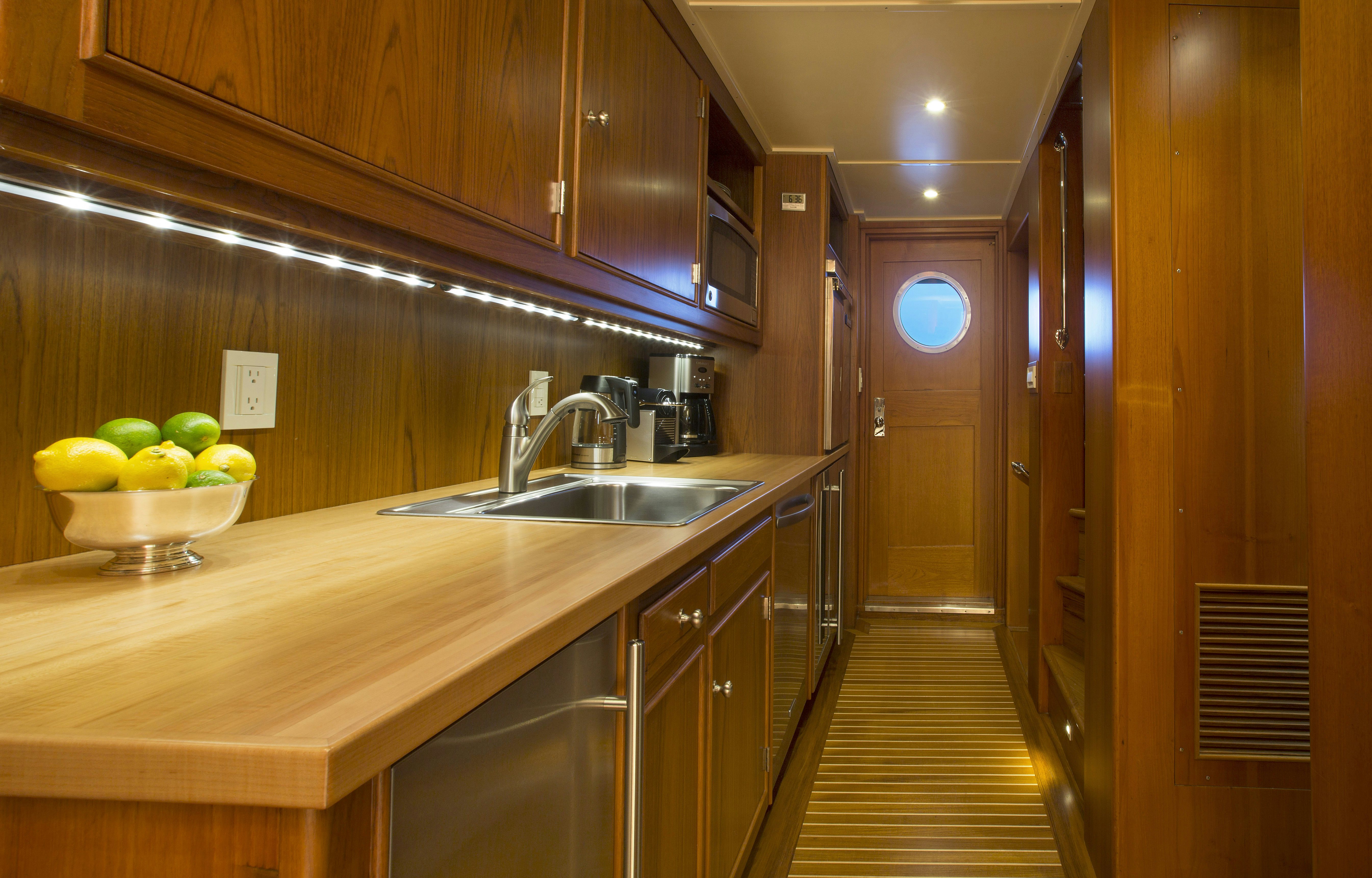 a kitchen with wooden cabinets aboard STONEFACE Yacht for Sale
