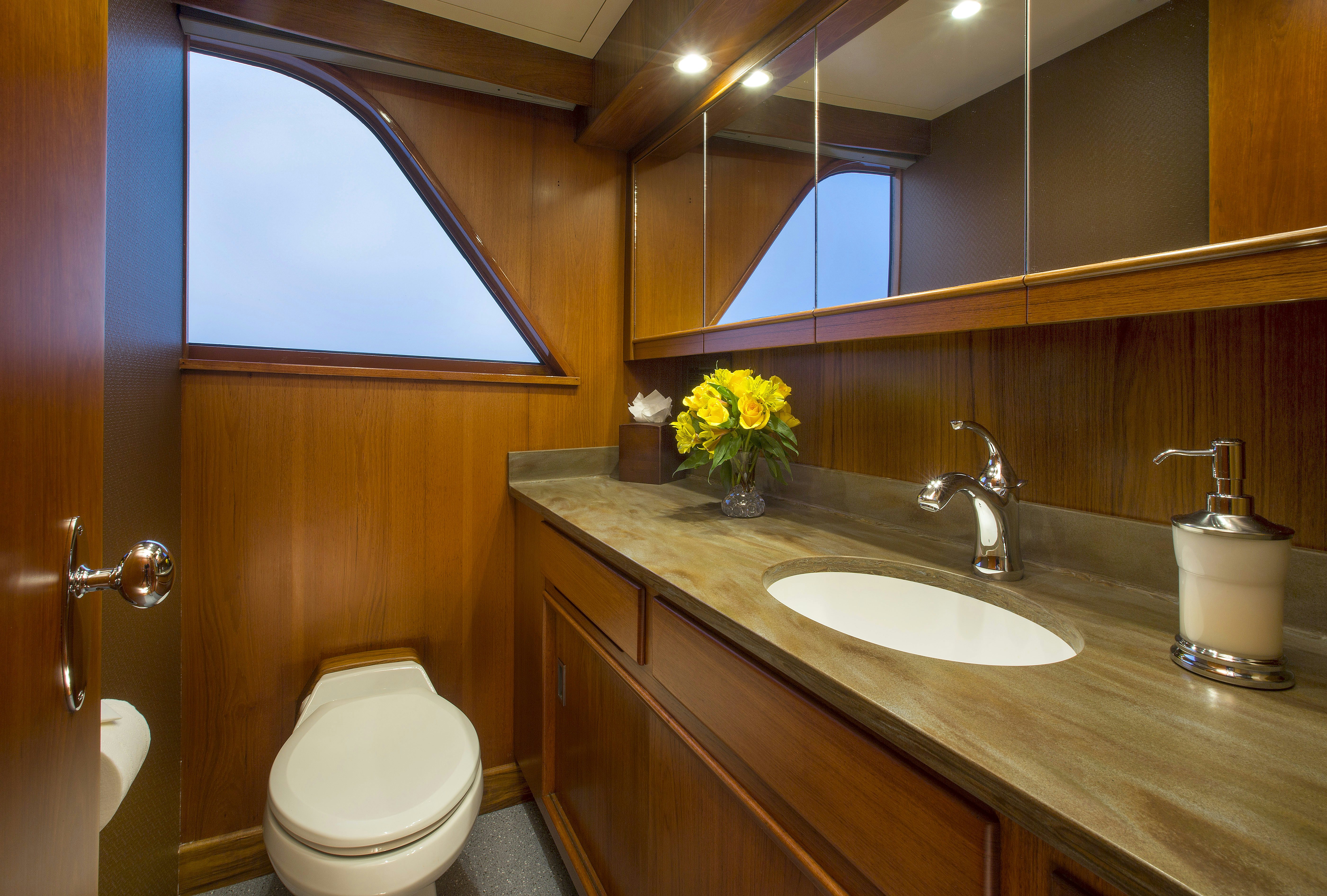 a bathroom with a sink toilet and a mirror aboard STONEFACE Yacht for Sale