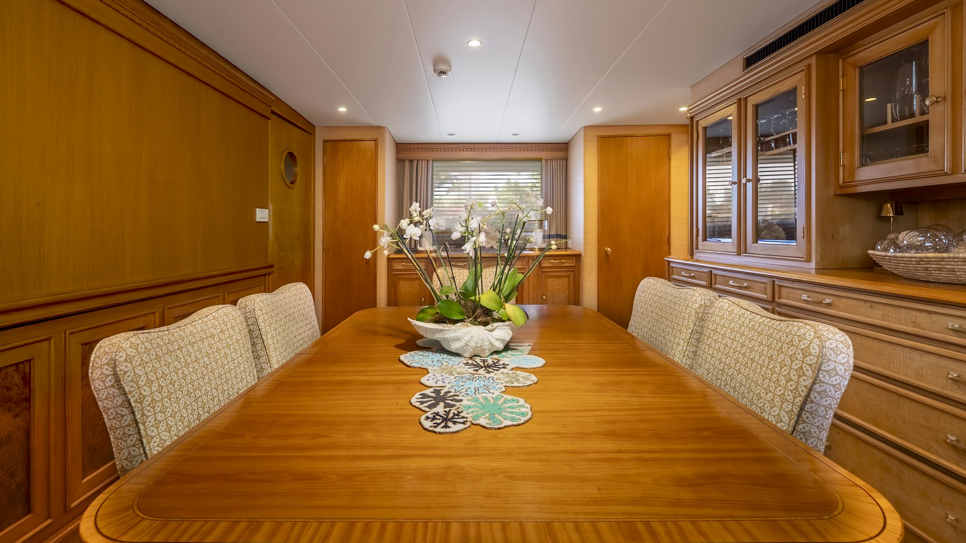 a dining table with a vase of flowers on it aboard STONEFACE Yacht for Sale