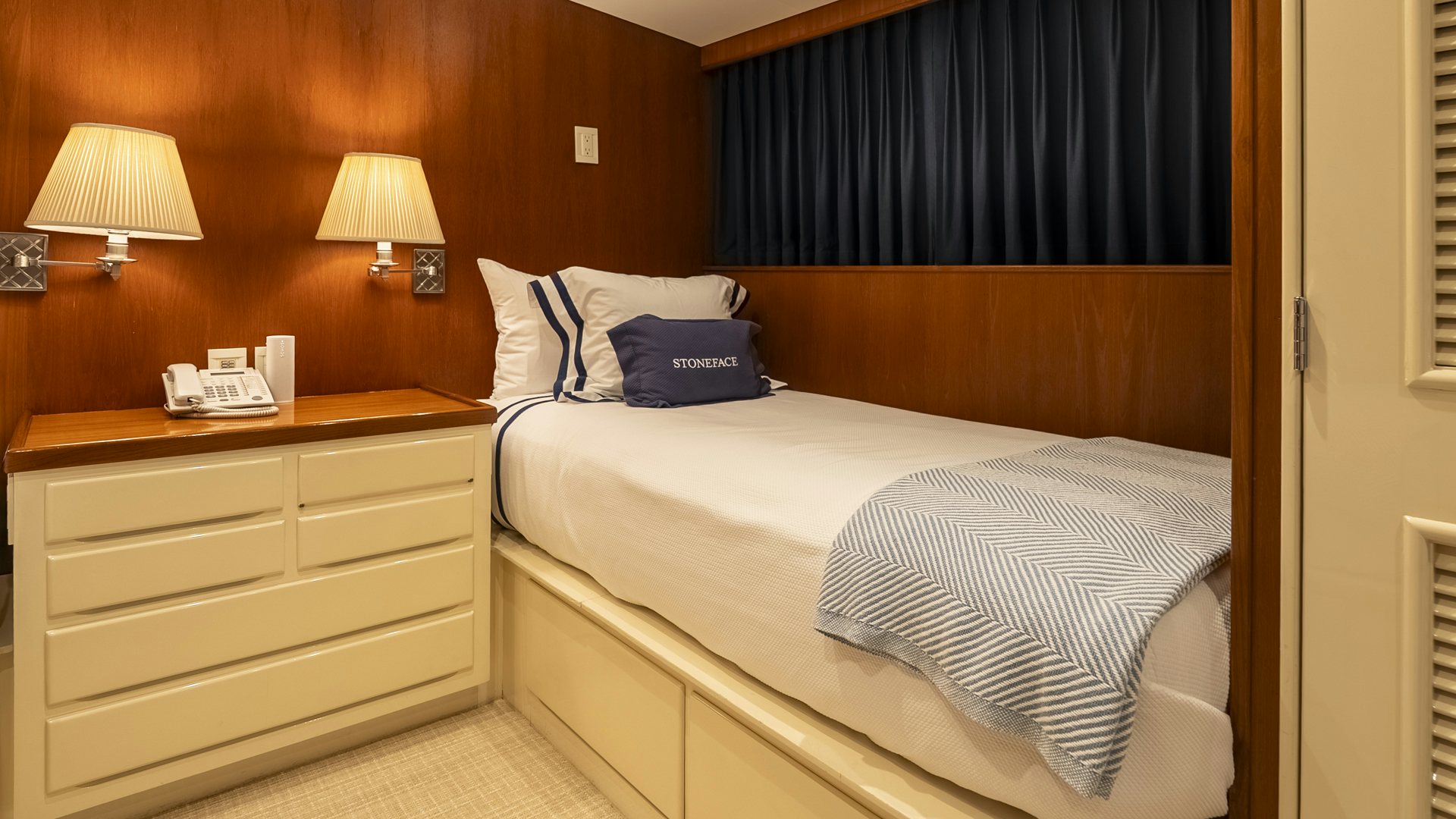 a bed with a white bed spread aboard STONEFACE Yacht for Sale