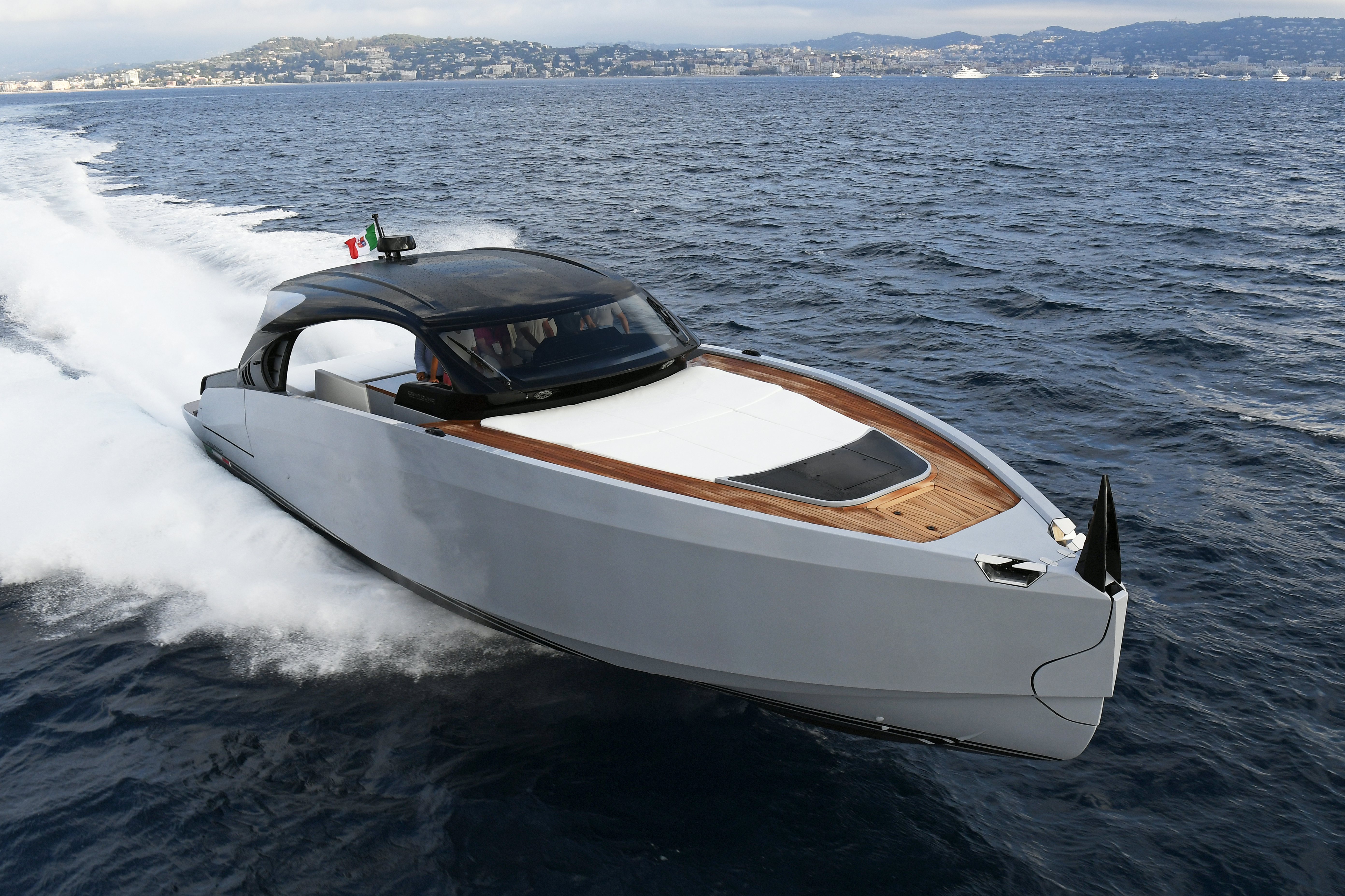 a white sports car driving on water aboard VESPRO 55 Yacht for Sale