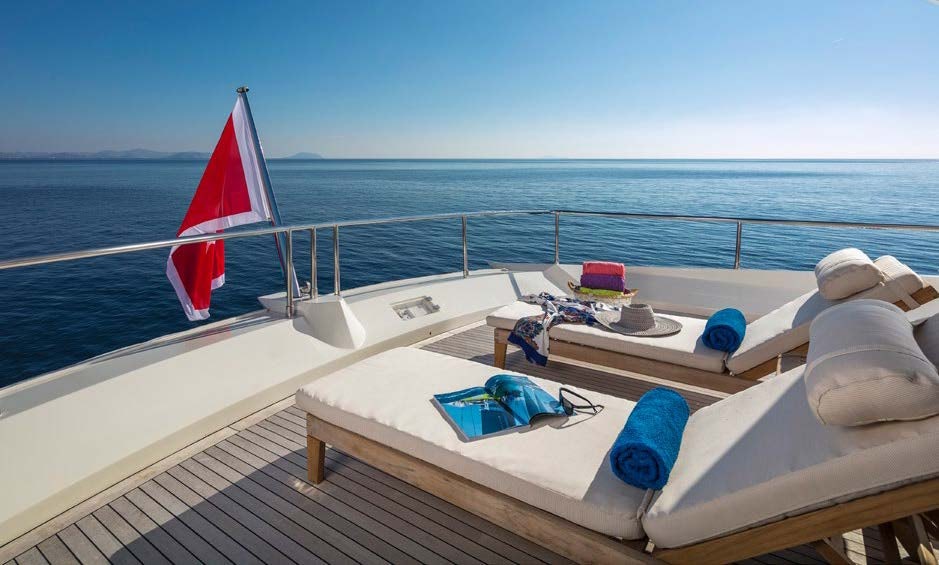 a boat with a red umbrella aboard RINI V Yacht for Charter
