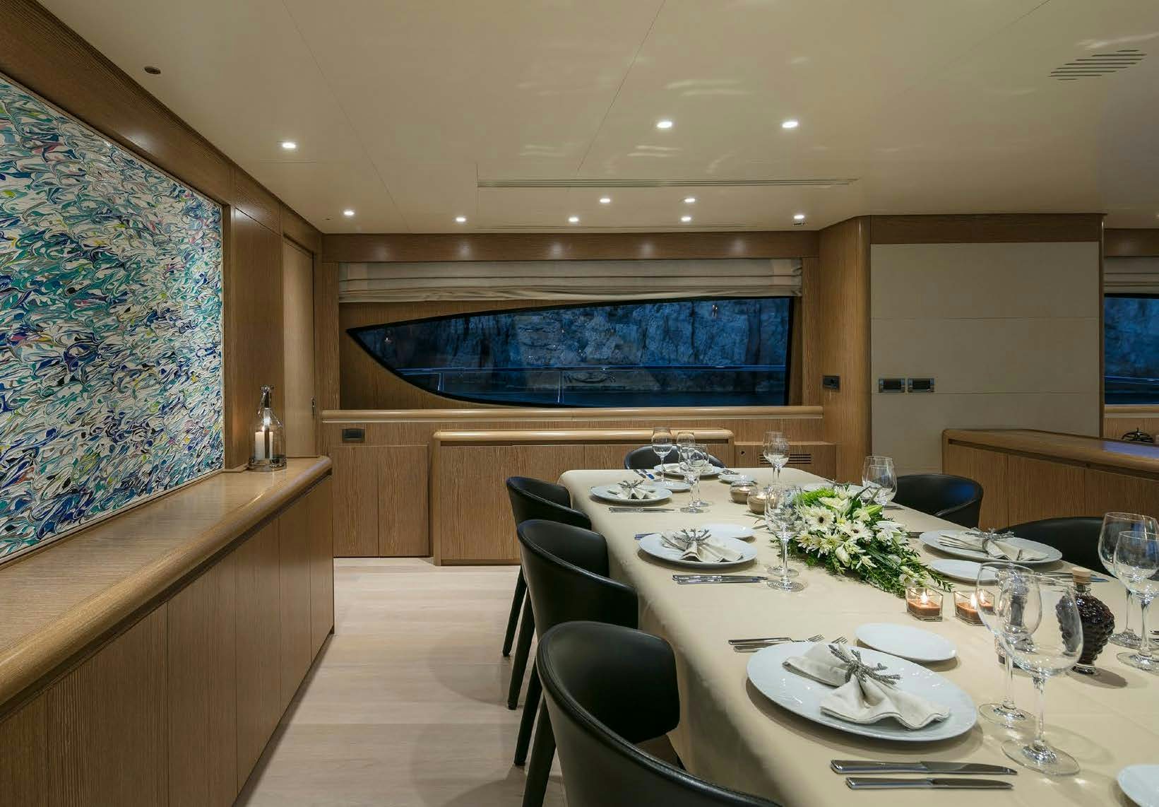 a dining room with a large painting aboard RINI V Yacht for Charter