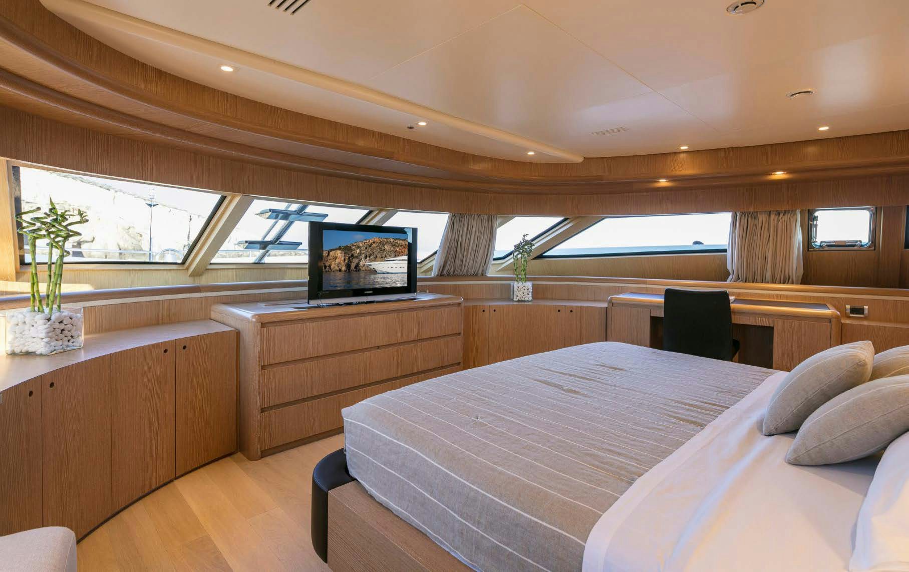 a bedroom with a bed and a tv aboard RINI V Yacht for Charter