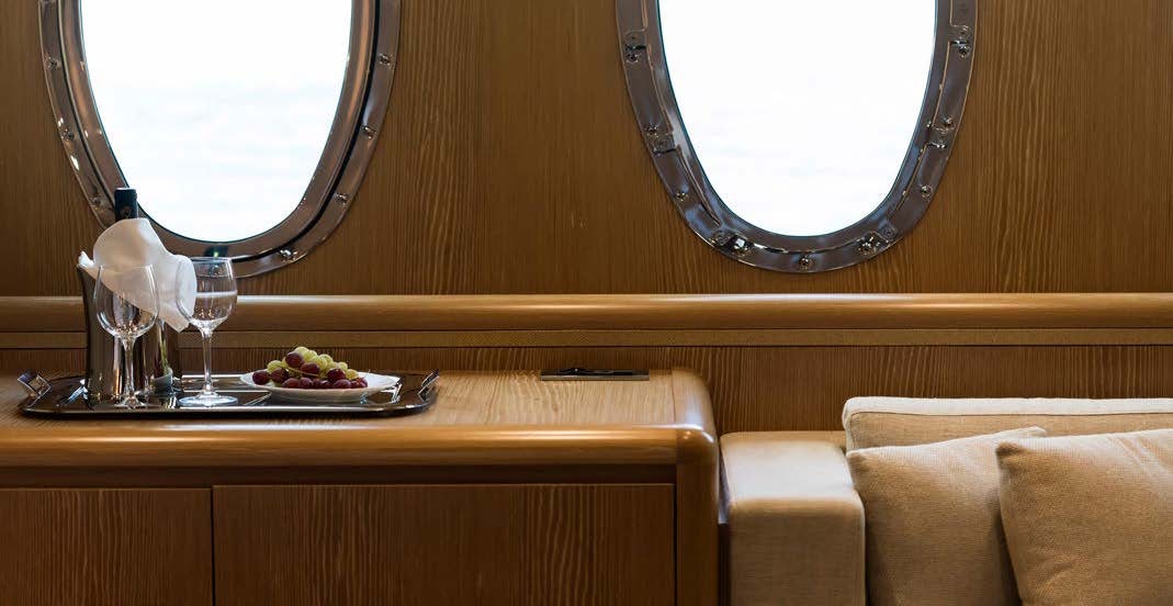 a table with a plate of food and a glass of wine on it aboard RINI V Yacht for Charter