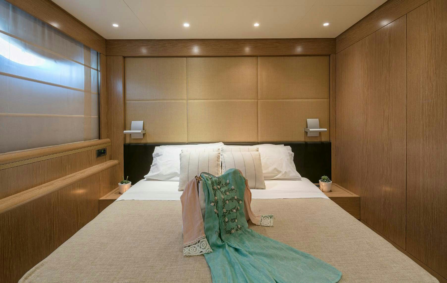 a room with a bed and a wood wall aboard RINI V Yacht for Charter