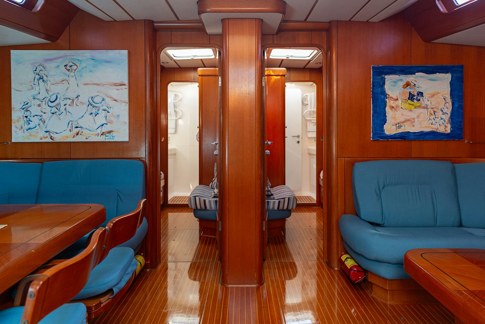a room with a wood floor and blue couches aboard DAG Yacht for Sale