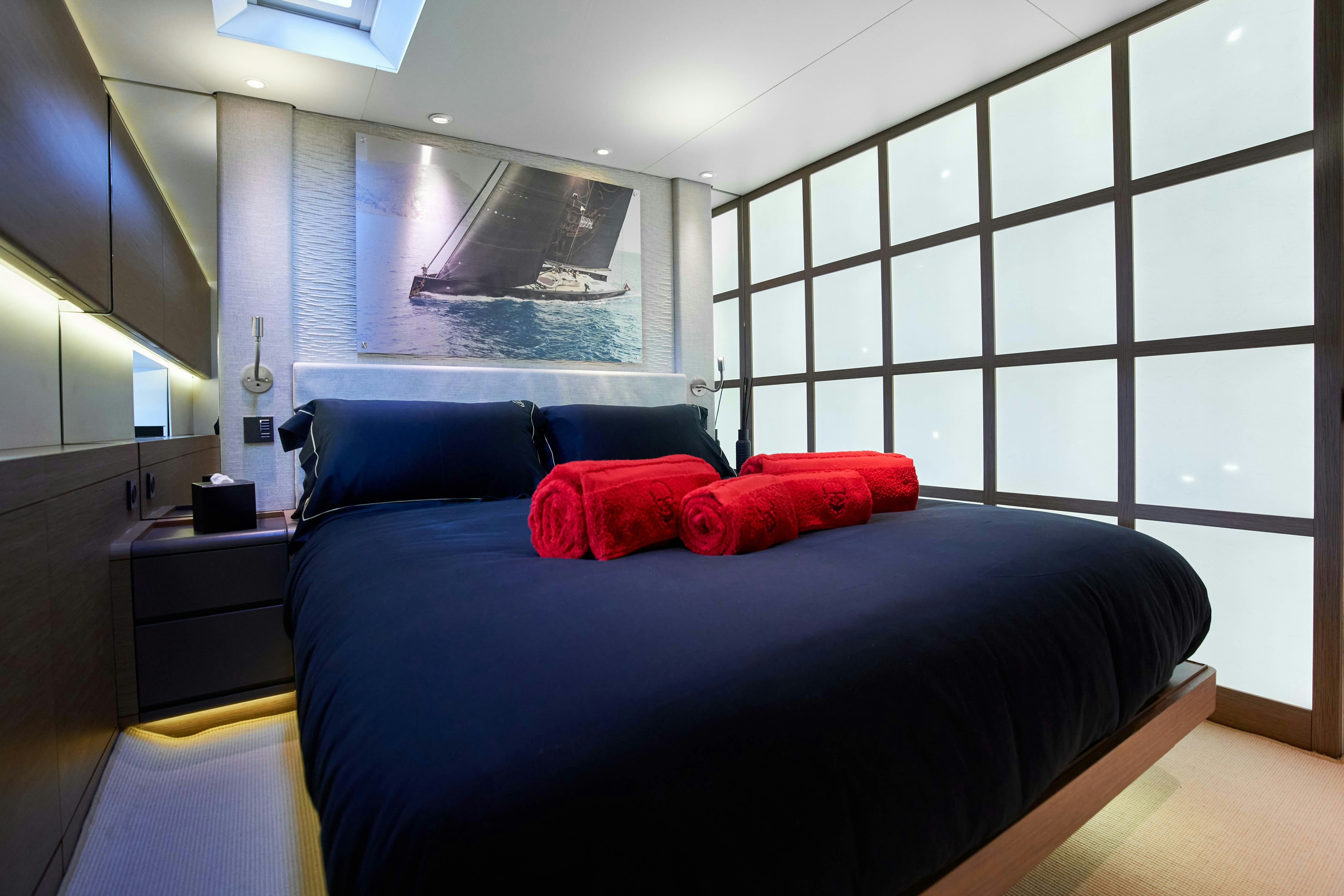 a bedroom with a blue bed aboard BLACK SAILS Yacht for Sale