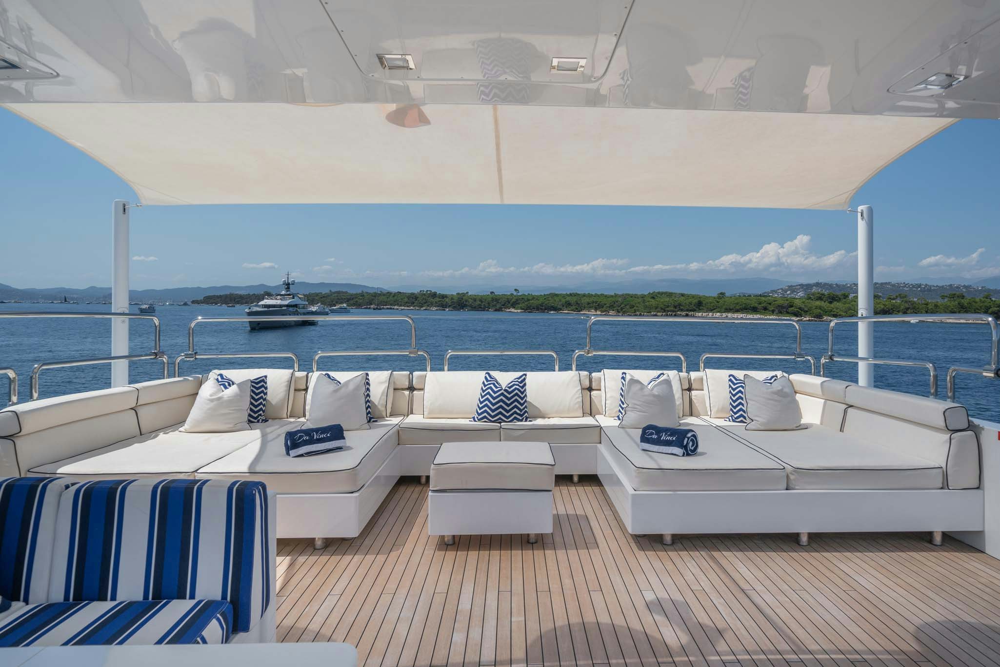 a lounge area with lounge chairs and a large body of water aboard DA VINCI Yacht for Charter