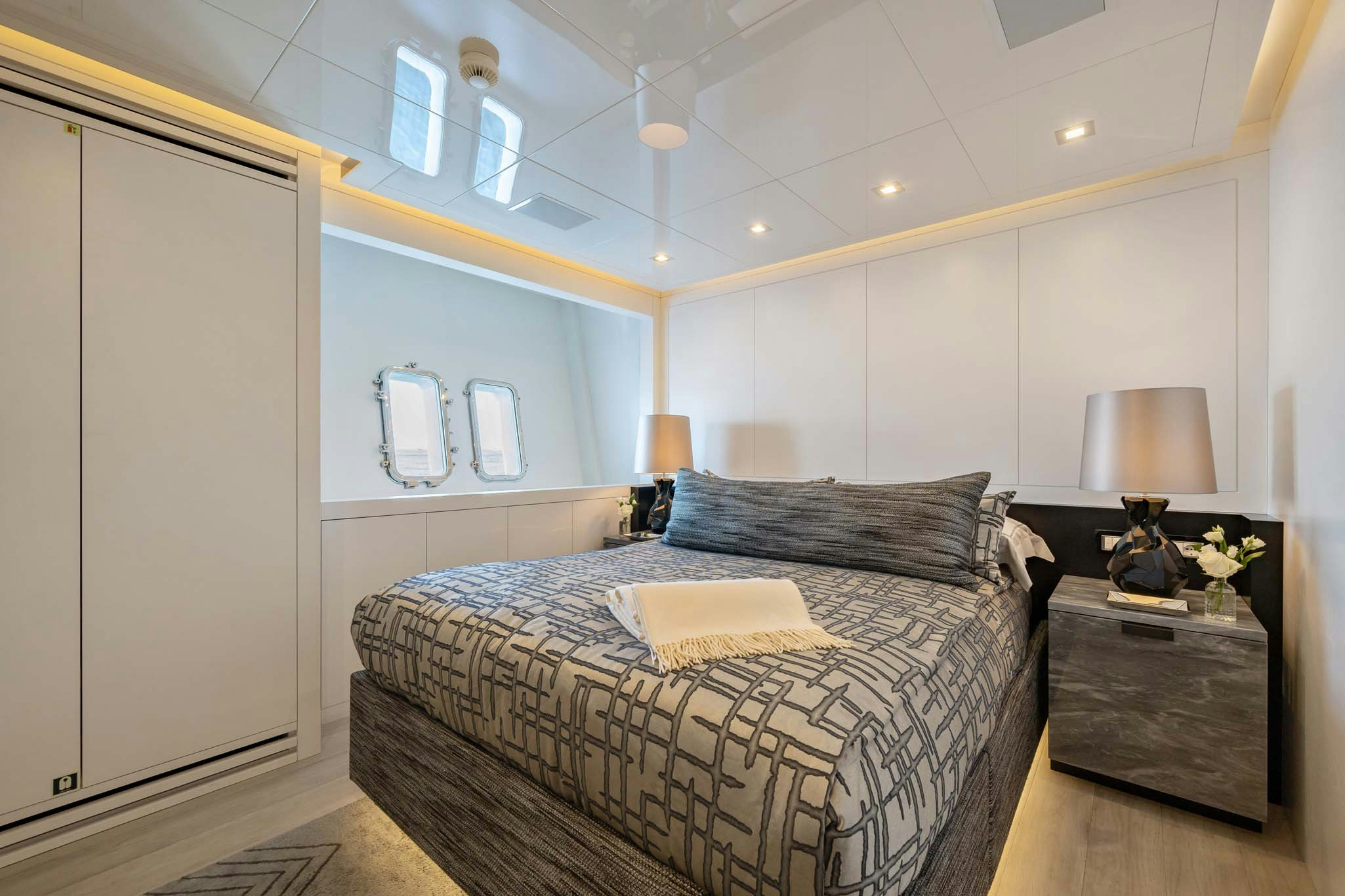 a bedroom with a bed and a lamp aboard DA VINCI Yacht for Charter