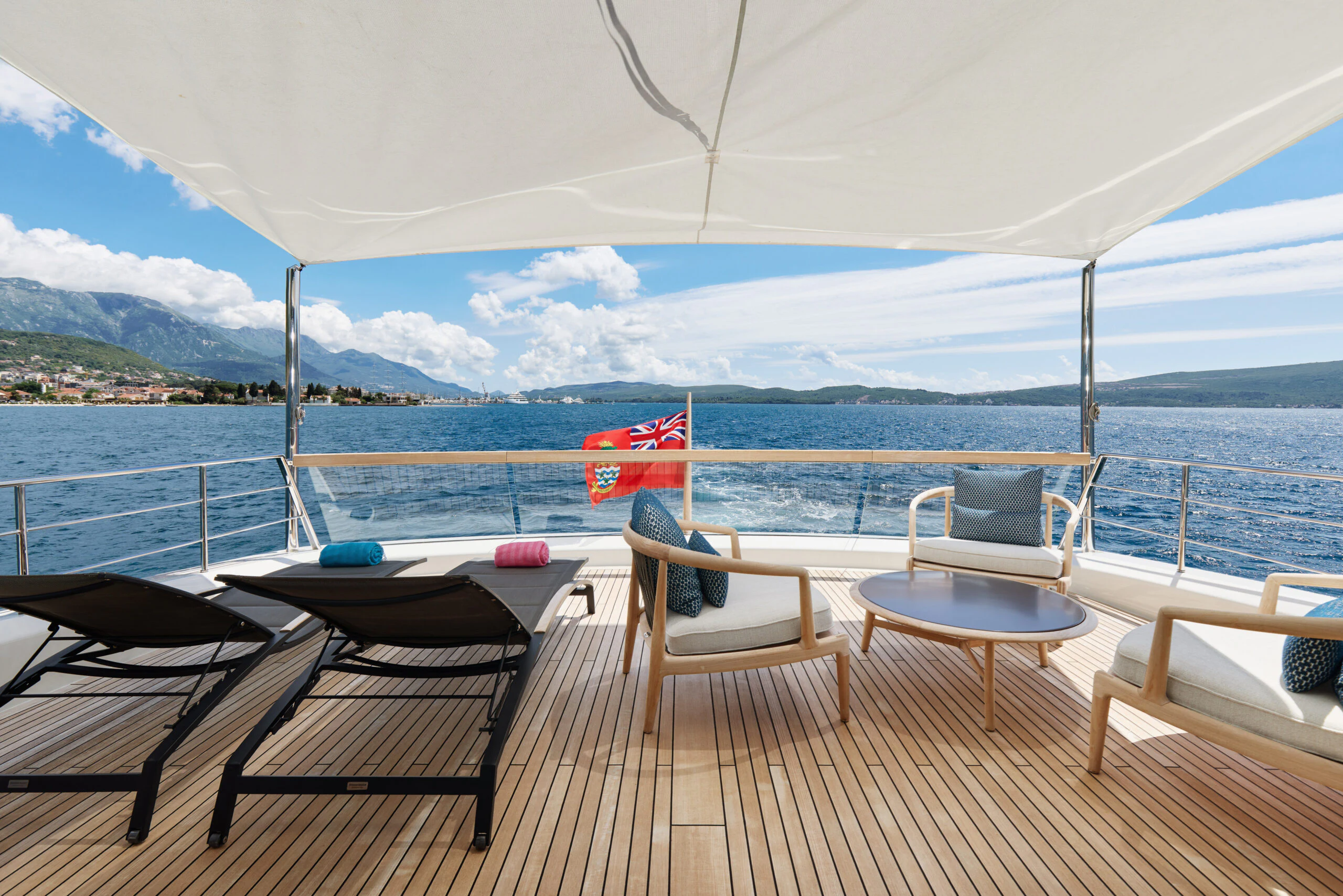 a deck with chairs and a flag on it aboard ZAFFIRO III Yacht for Sale