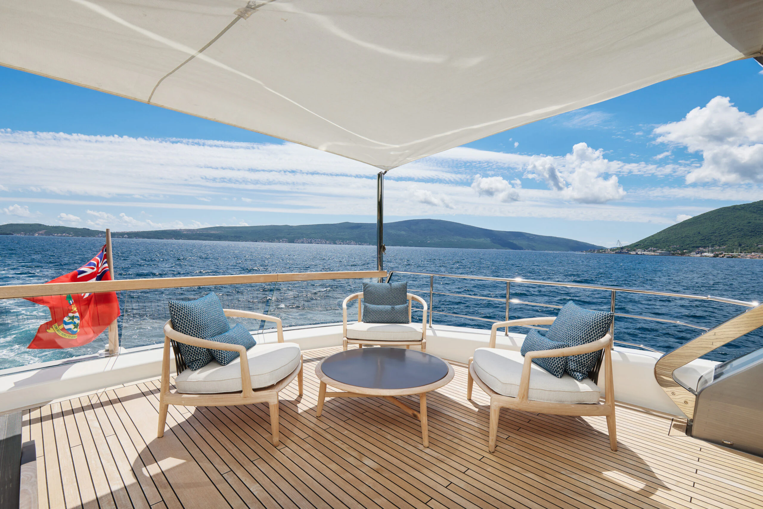 a deck with chairs and a flag on it aboard ZAFFIRO III Yacht for Sale