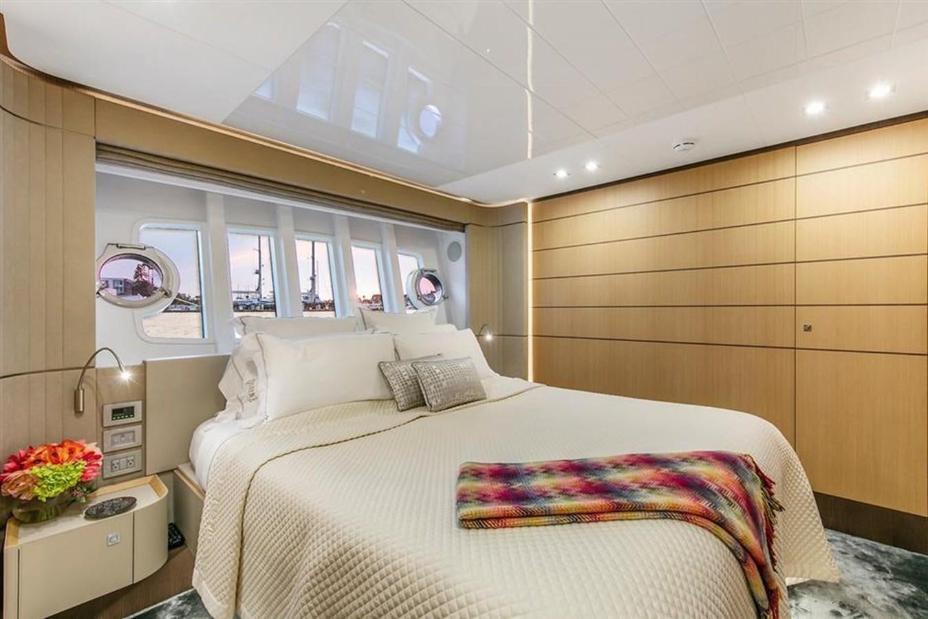 a bedroom with a bed and a window aboard LONTANO Yacht for Sale