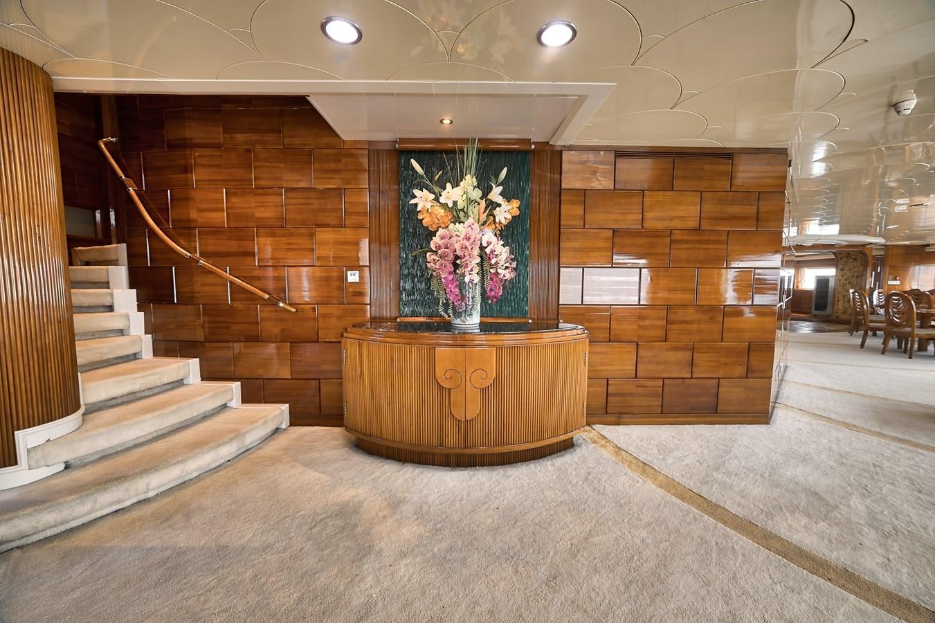 a large room with a staircase and a vase with flowers in it aboard ASEAN LADY Yacht for Sale