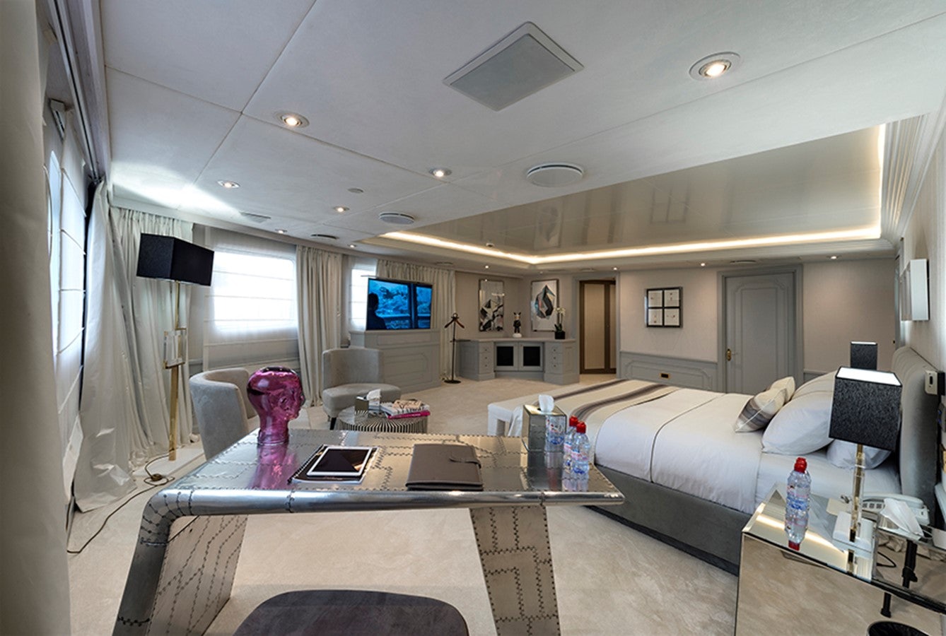 a room with a bed and a table aboard CHAKRA Yacht for Charter