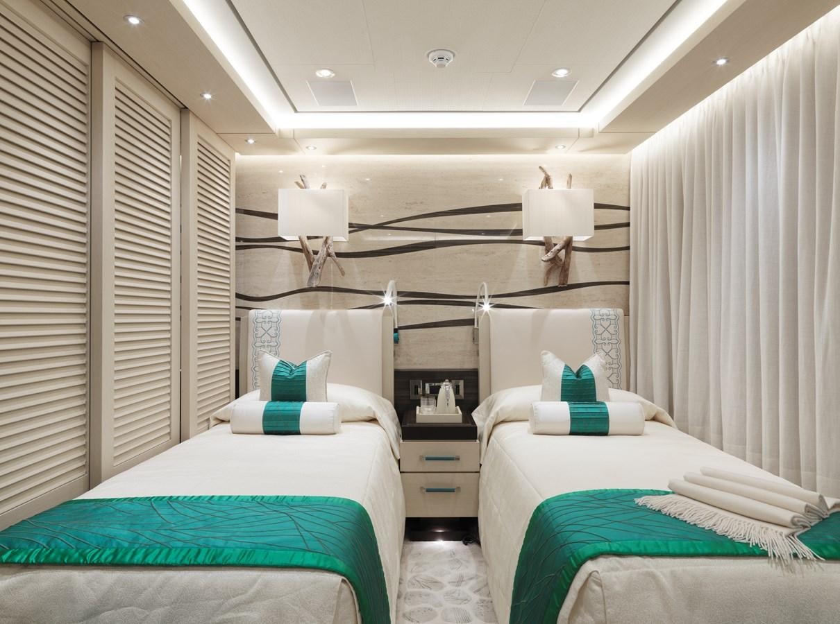 a room with beds and a lamp aboard DRAAK Yacht for Sale