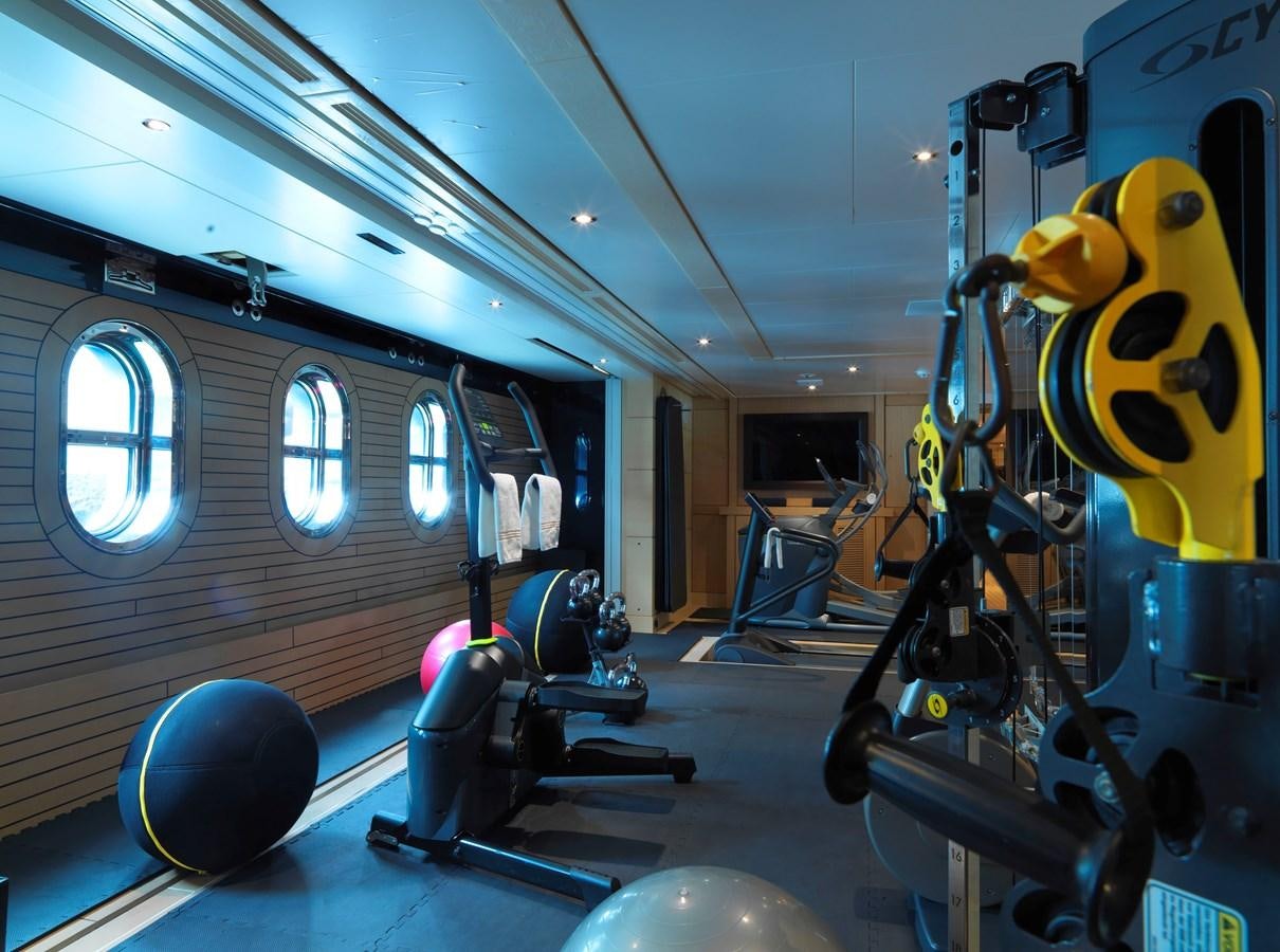 a large gym with exercise equipment aboard DRAAK Yacht for Sale