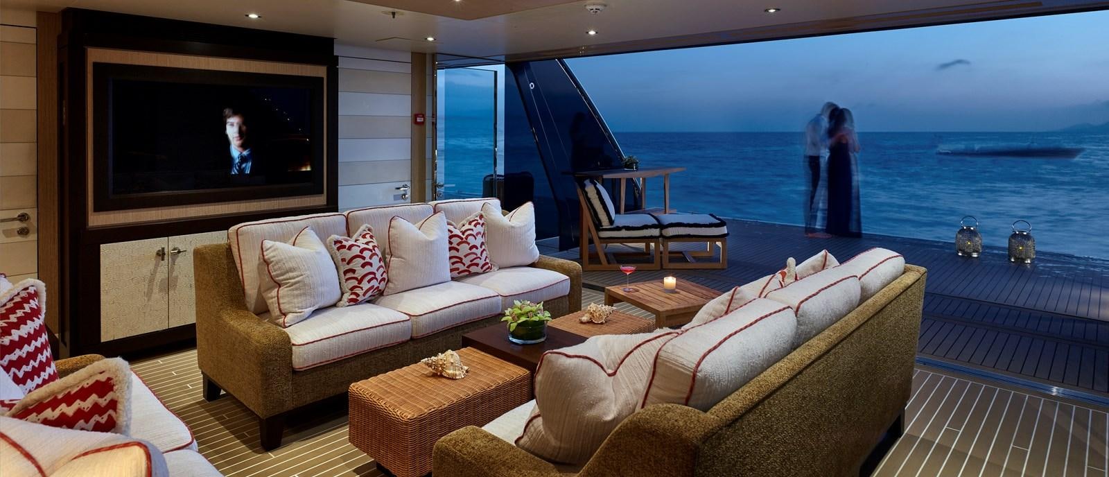 a living room with a large television and a large body of water aboard DRAAK Yacht for Sale