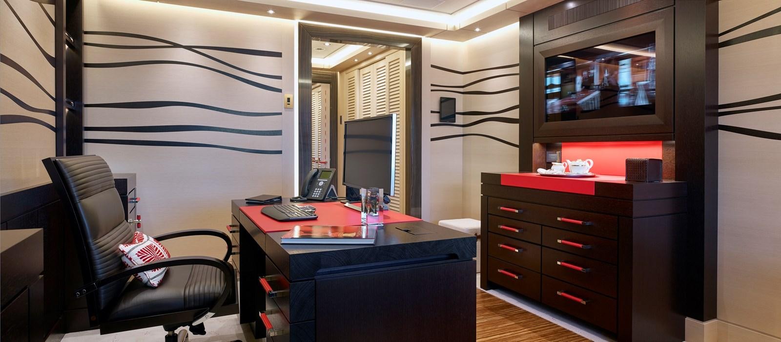 a room with a desk and a tv aboard DRAAK Yacht for Sale