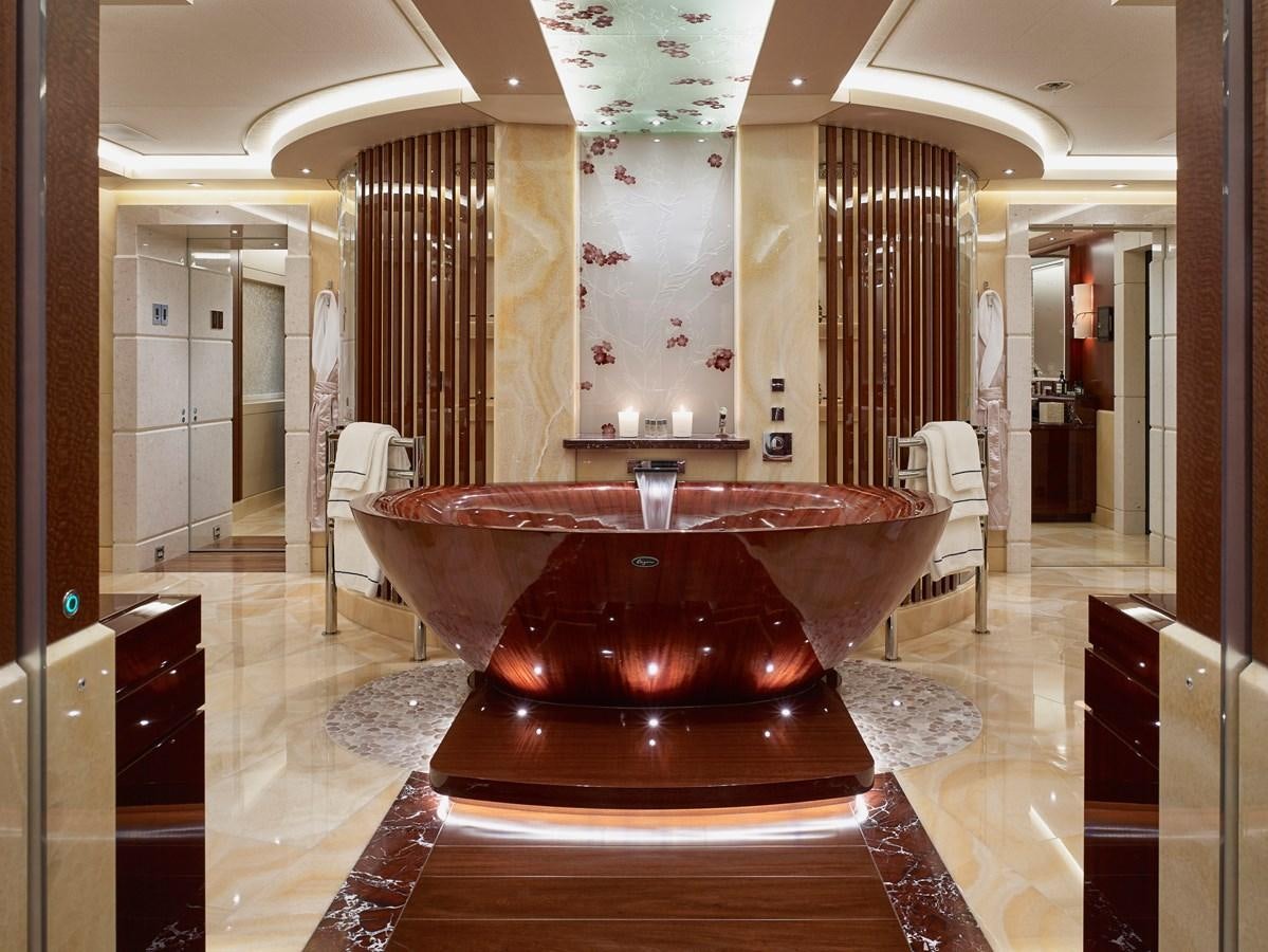 a large round red table in a room with chairs and a large chandelier aboard DRAAK Yacht for Sale