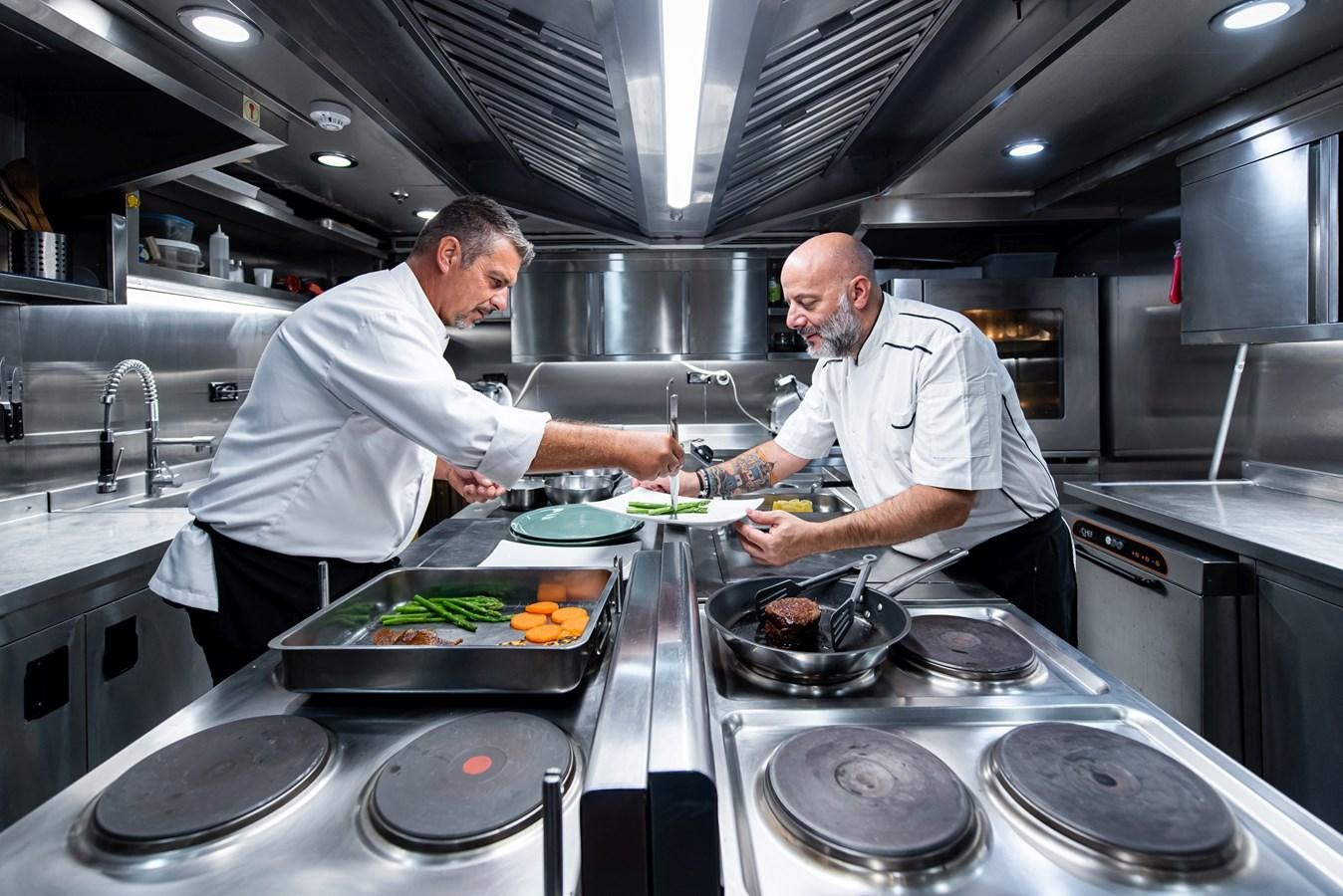 a couple of chefs in a kitchen aboard BLEU DE NIMES Yacht for Sale