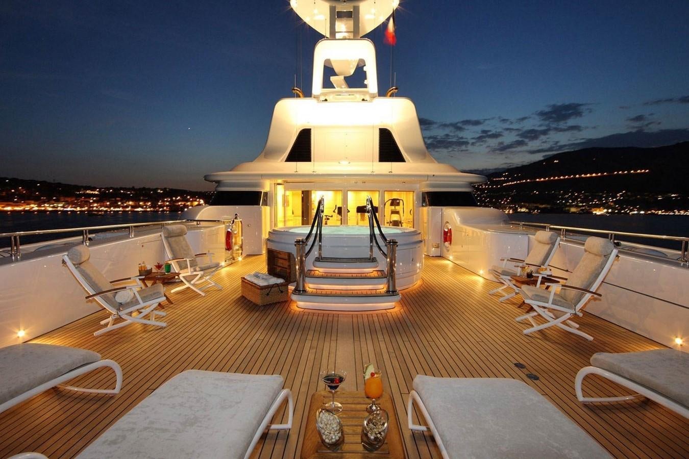 a building with a tower and a table with chairs and a lamp on it aboard CAPRI I Yacht for Sale