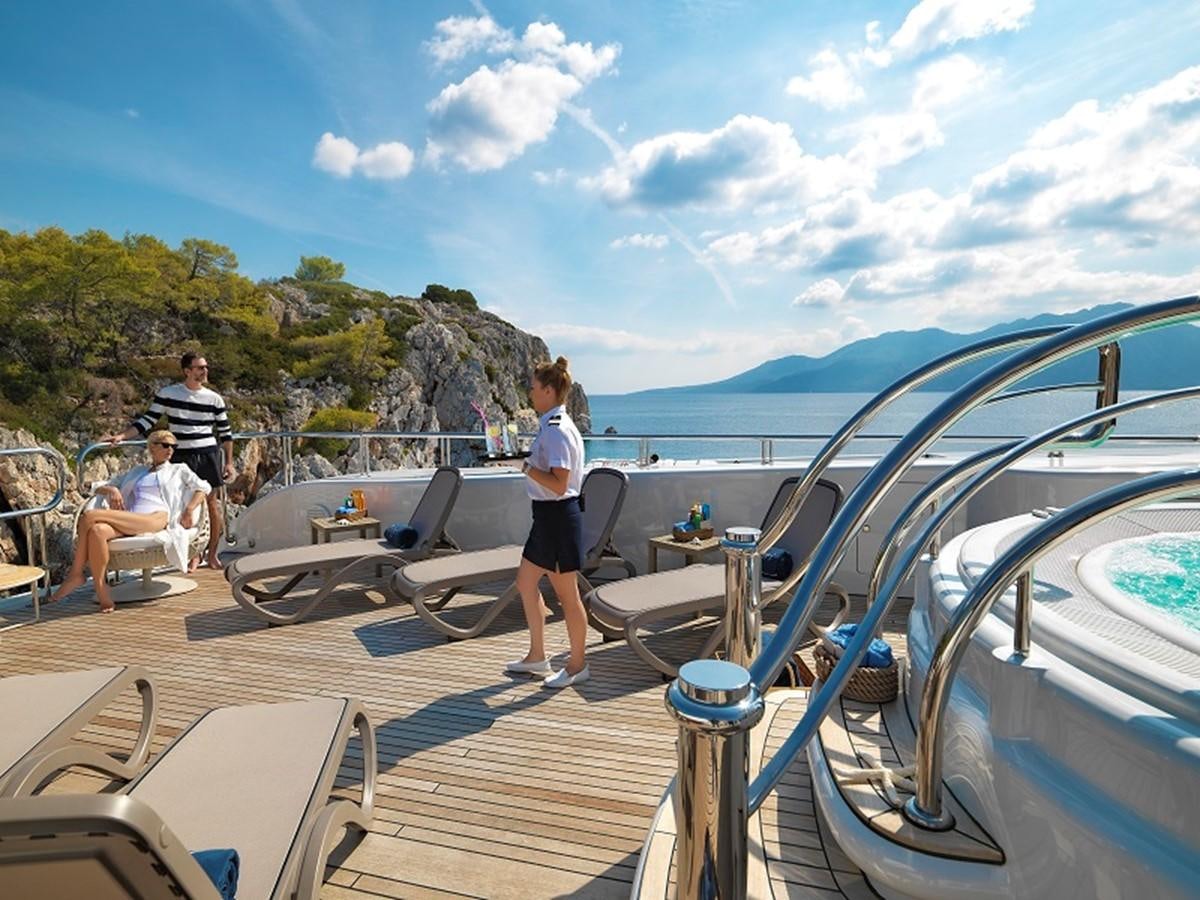 people on a deck looking at a boat on the water aboard CAPRI I Yacht for Sale