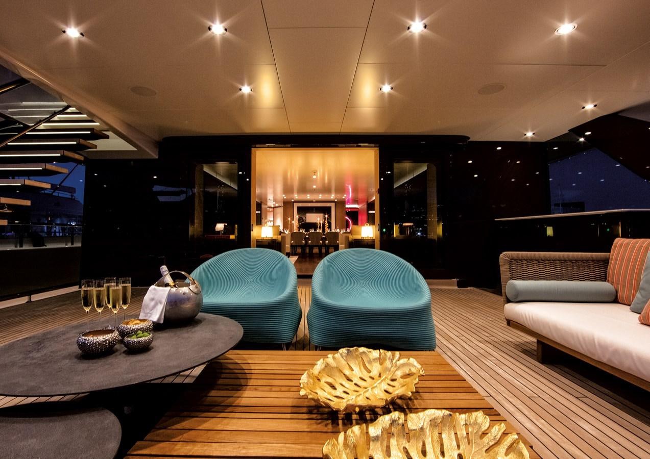 a living room with a large glass table and a large mirror aboard HALO Yacht for Sale