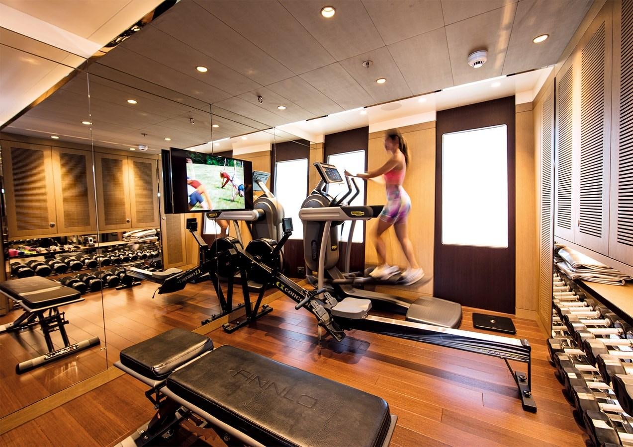 a person on a treadmill in a gym aboard HALO Yacht for Sale