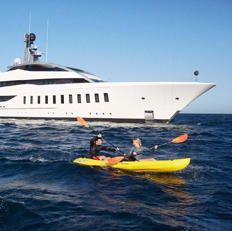 a couple of people in a kayak in front of a boat aboard HALO Yacht for Sale