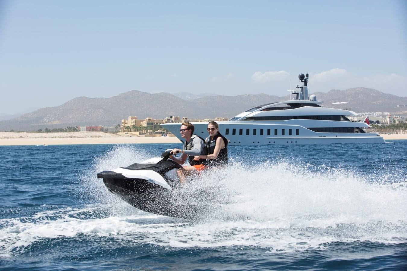 a man and a woman riding a jet ski in the water aboard HALO Yacht for Sale