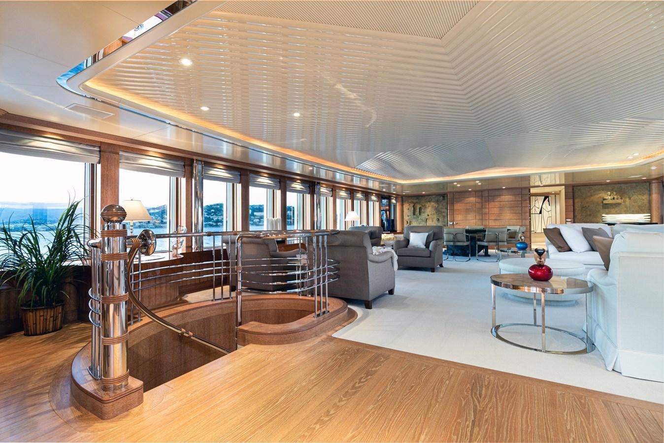 a large living room with a staircase aboard SEA HUNTRESS Yacht for Sale