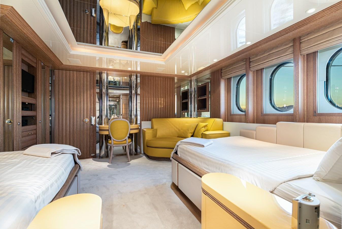 a room with beds and a chair aboard SEA HUNTRESS Yacht for Sale