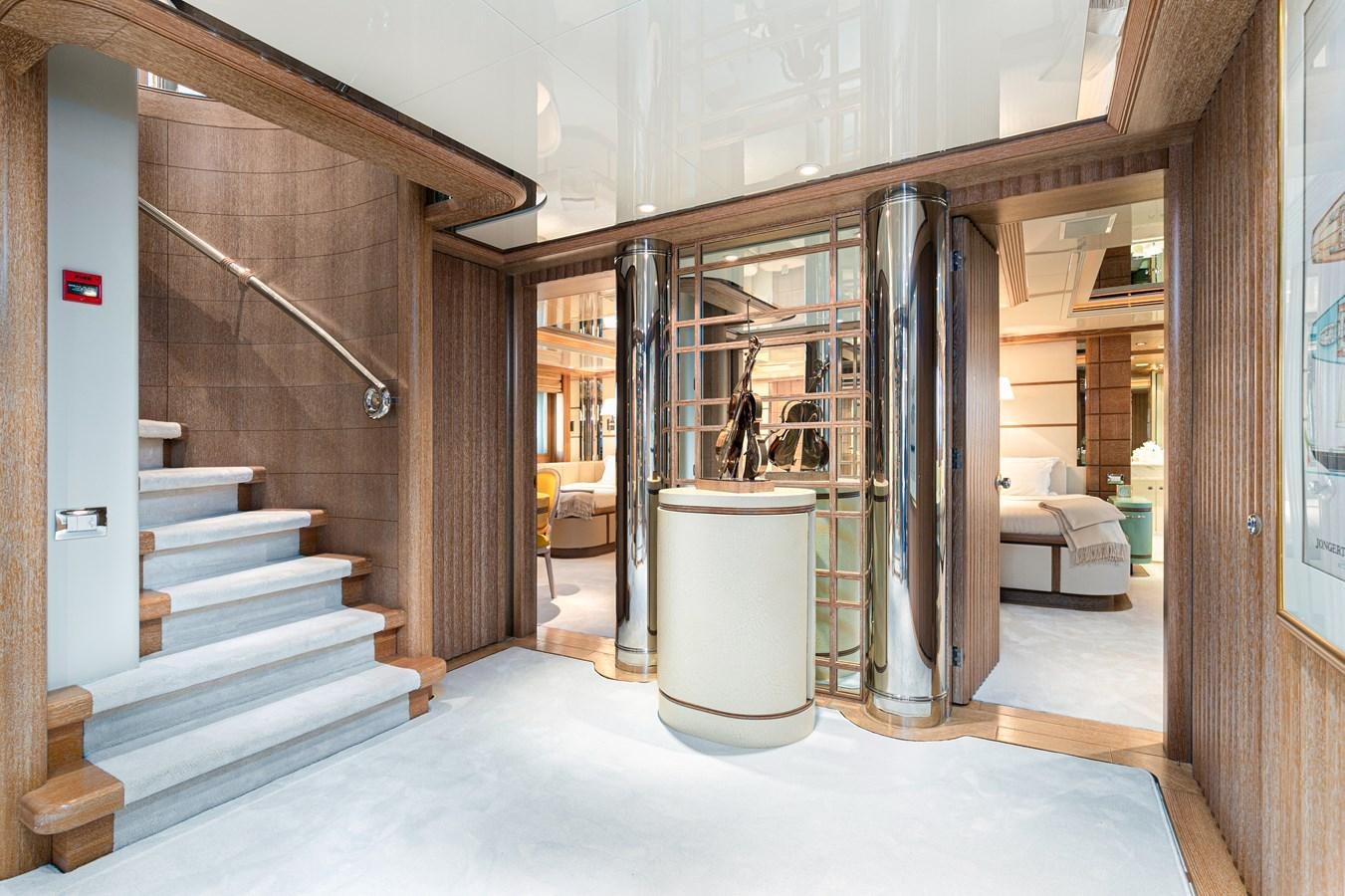 a large room with a staircase and a glass door aboard SEA HUNTRESS Yacht for Sale