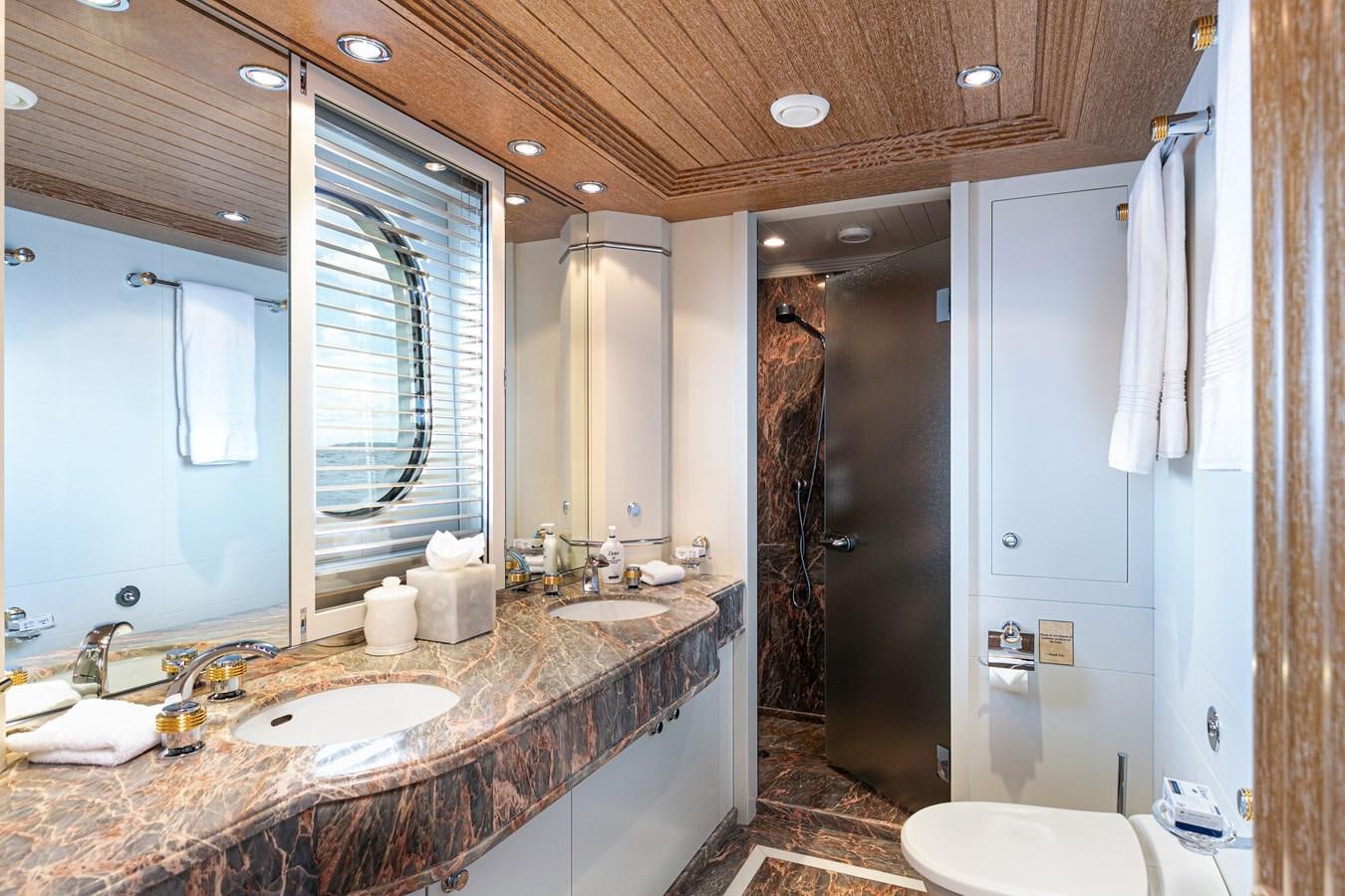 a bathroom with a countertop sink and a shower unit aboard SEA HUNTRESS Yacht for Sale