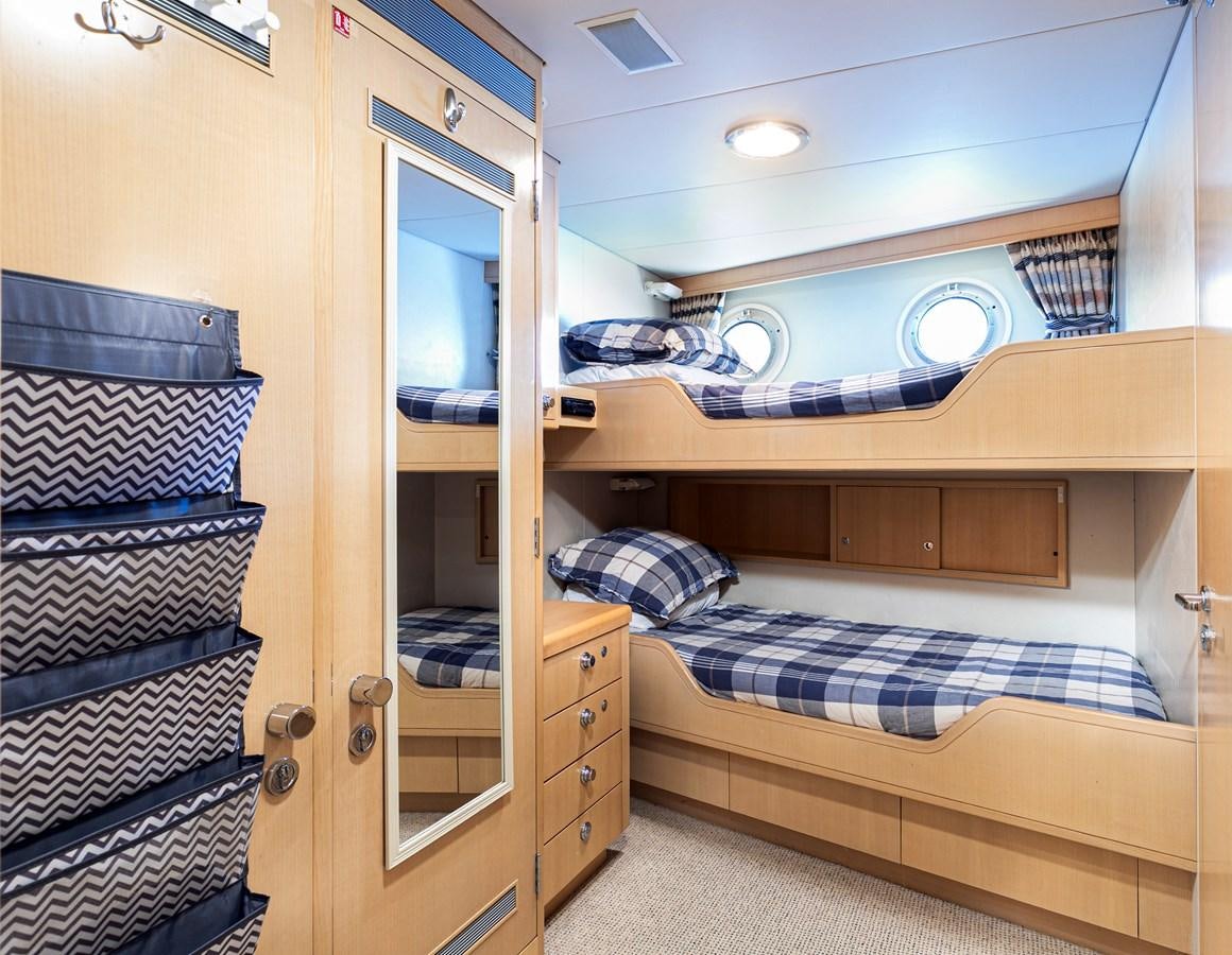 a bunk bed with a blue comforter aboard SEA HUNTRESS Yacht for Sale