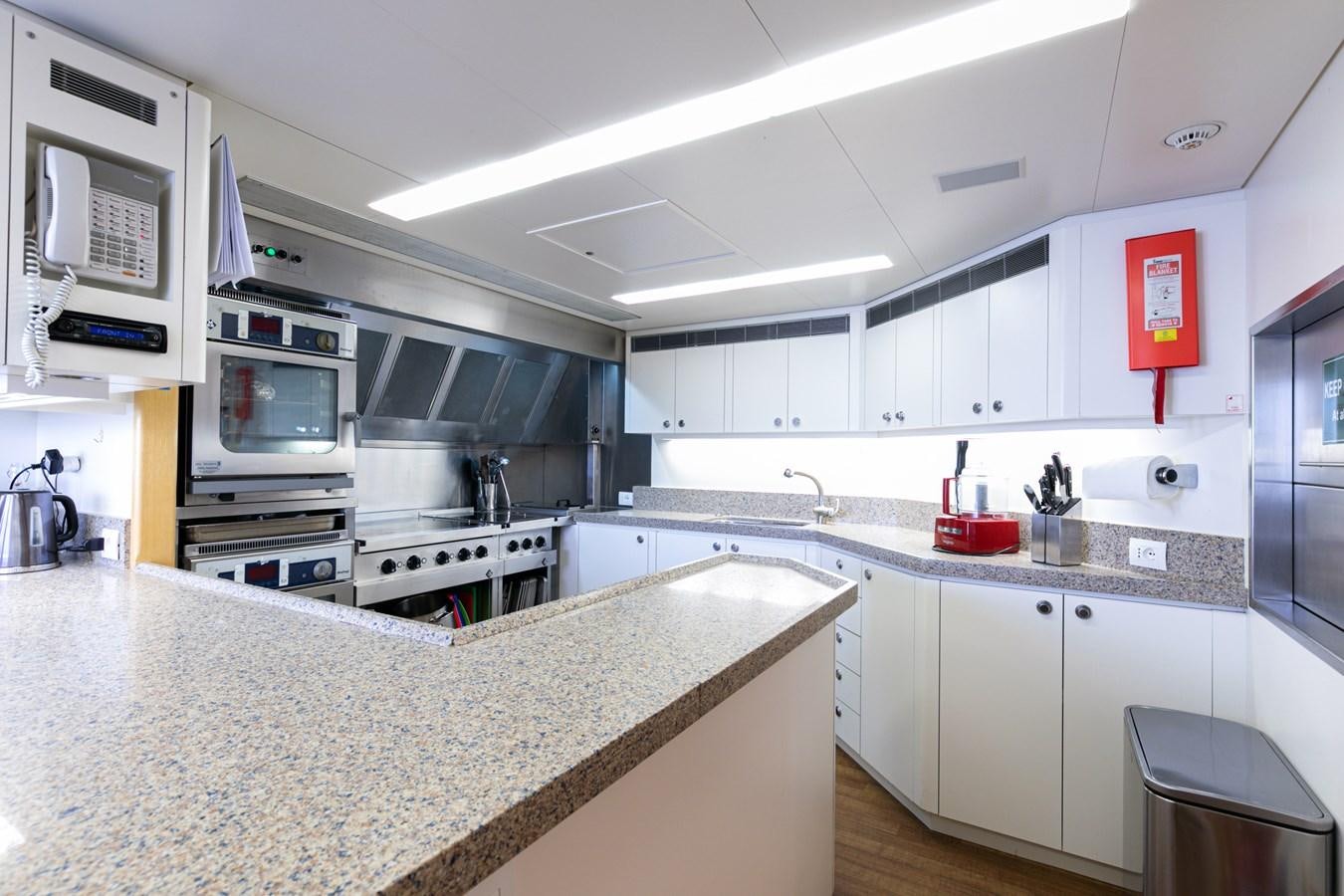 a kitchen with white cabinets aboard SEA HUNTRESS Yacht for Sale