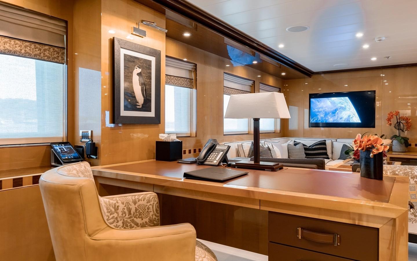 a room with a desk and a tv on the wall aboard LIND Yacht for Charter