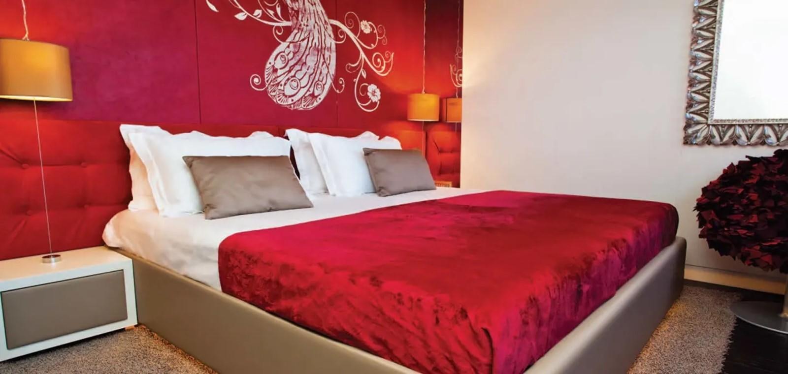 a bed with a red comforter aboard JOY ME Yacht for Charter