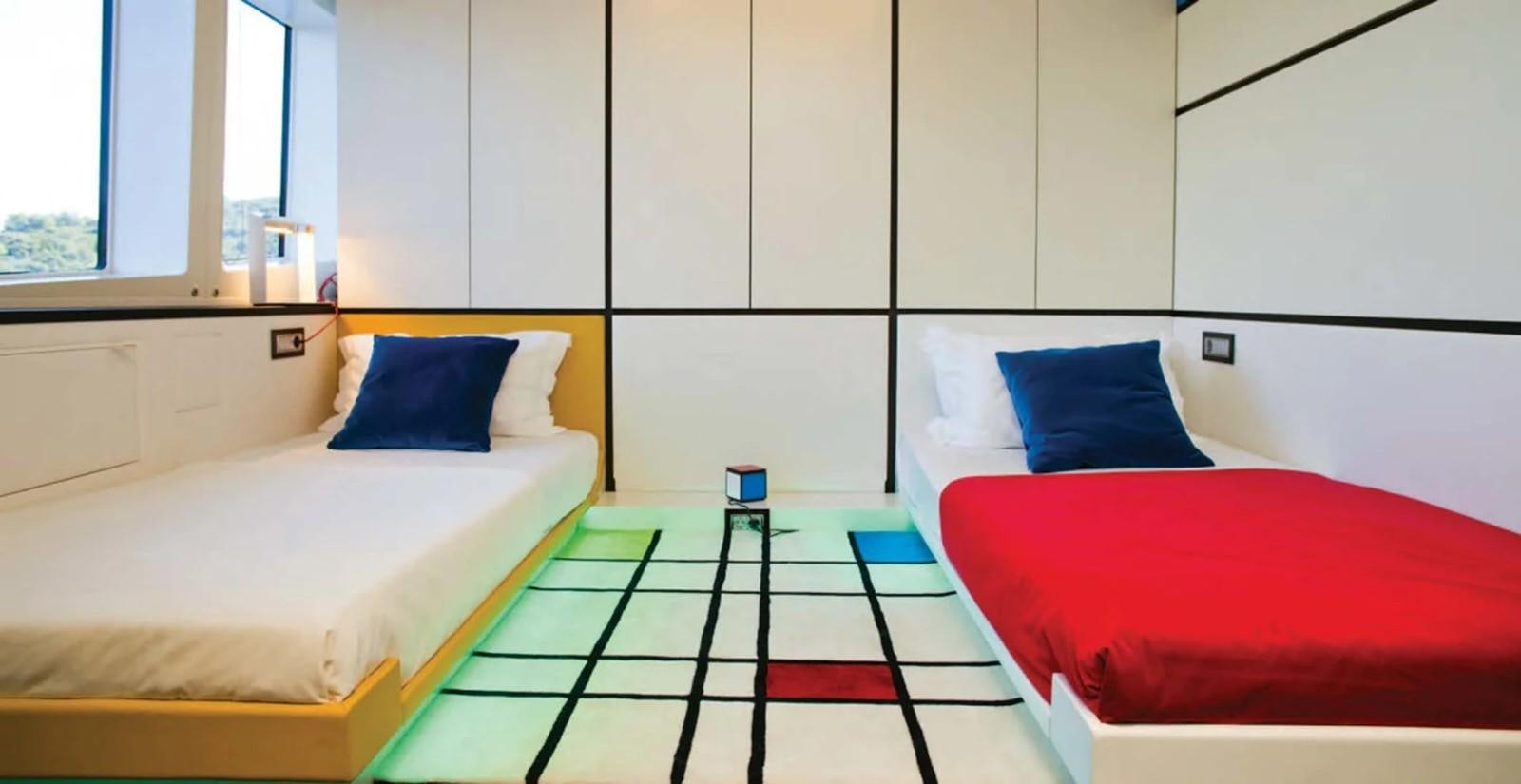 a room with beds and a rug aboard JOY ME Yacht for Charter