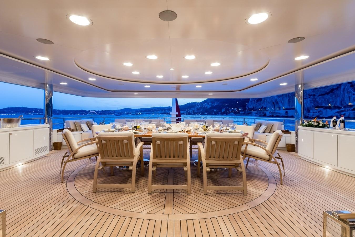 a large room with a table and chairs and a large pool aboard ELENI Yacht for Sale