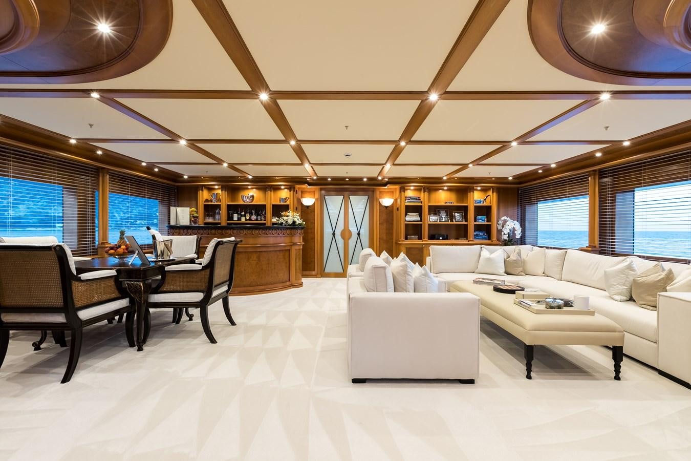 a living room with a large white couch and a large window aboard ELENI Yacht for Sale